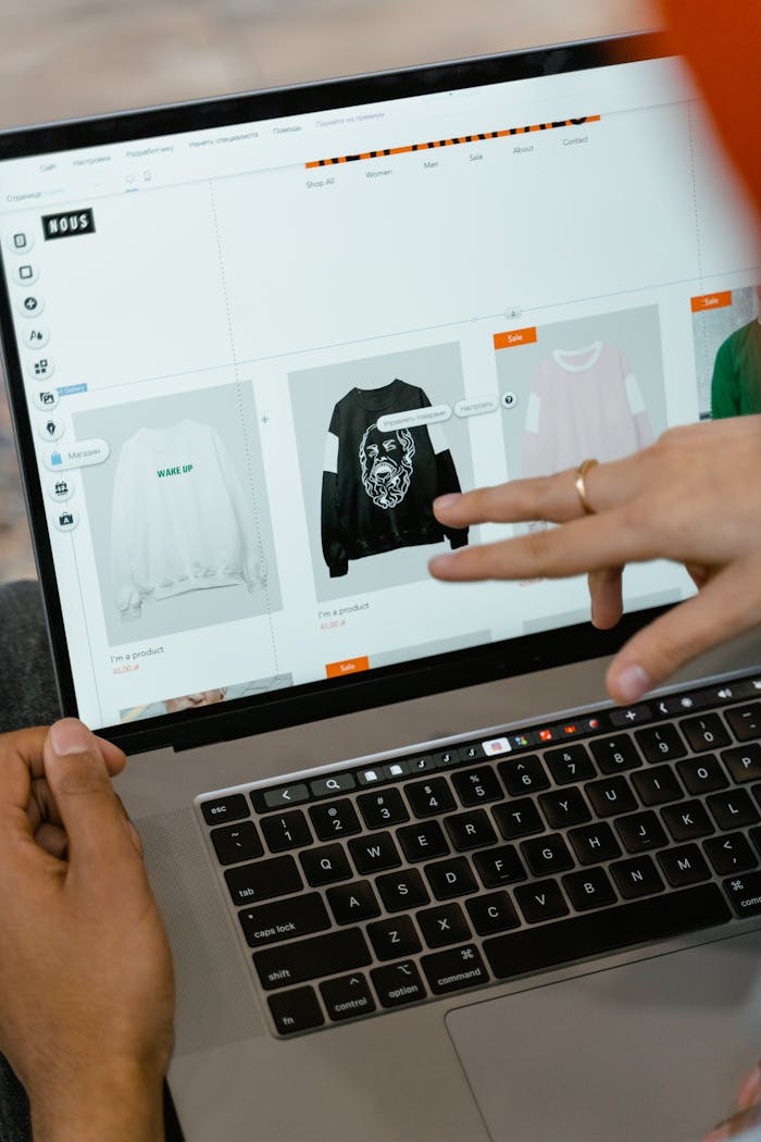 Services Close-up of hands interacting with a shopping website on a laptop screen indoors.